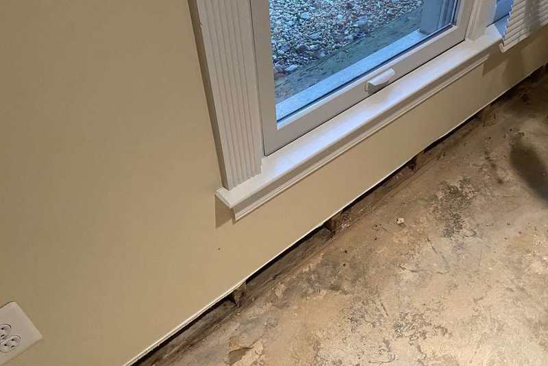 Exposed basement wall and slab edge being reviewed during a water-source evaluation