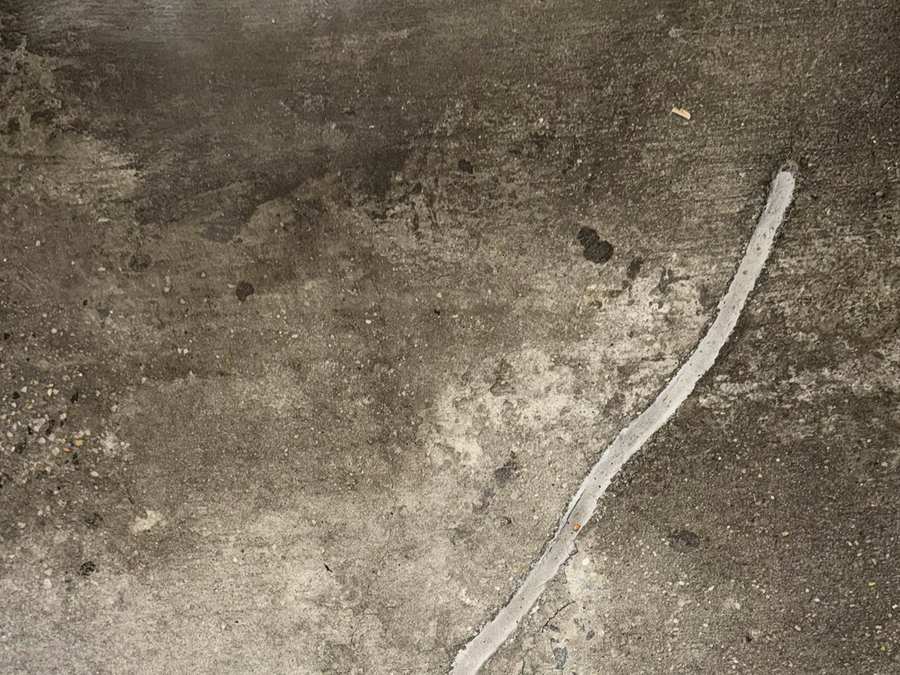 Visible sealed crack in an existing concrete parking garage floor