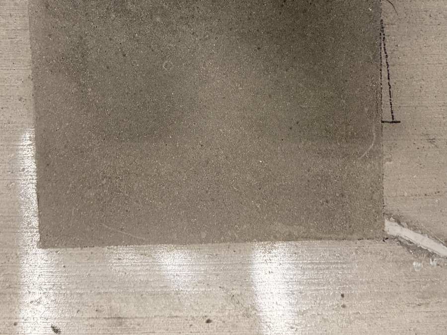 Placed rectangular concrete patch within a prepared parking garage floor repair area