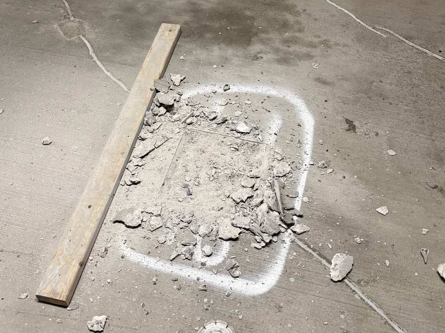 Marked localized parking garage concrete repair area during removal